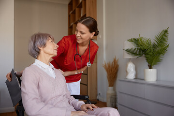 Portrait of female doctor talking to her patient during home visit - 787133001