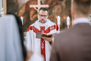 Valmiera, Latvia- July 28, 2024 - A priest in liturgical vestments reads from a book during a...