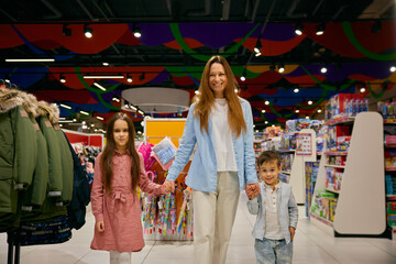 Portrait of happy mother with little children in shopping mall - 787133425