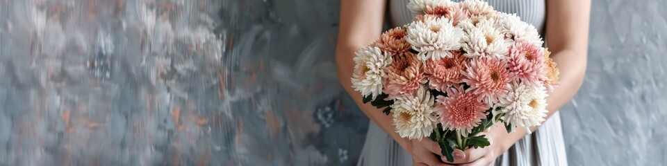 A woman hands gently hold a vibrant bouquet of chrysanthemums