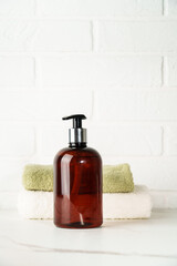Soap bottle and towel stack on white bathroom background. - 787136873
