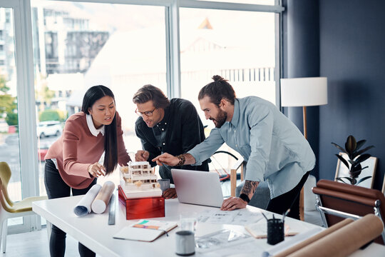 Business people, model and architecture with planning, cooperation for building renovation and talking. Group, engineering team and brainstorming with support or meeting for industrial project design