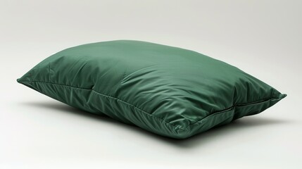 A dark green, puffy fabric pillow isolated on a white background