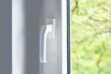 Handle of modern pvc plastic window in room, close up view