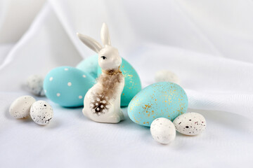 Easter composition with white rabbit and eggs on a white background. The minimal concept.