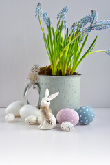 Easter composition with white rabbit, eggs and light blue muscari flowers in cup. Easter still life - 787152038