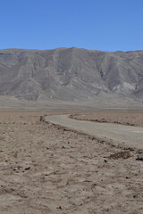 Fototapeta na wymiar Estrada no deserto com as cordilheiras ao fundo