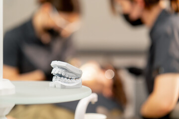 close-up in a dental office young guy lying on the table with a cast of the patients teeth against the background
