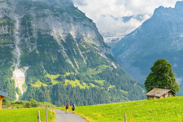 Two sporty woman hiking in Switzerland alps. Heathy lifestyle, sport, beauty in nature. Grindelwald valley, Swizz