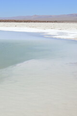 Lagoa de sal com cordilheira ao fundo