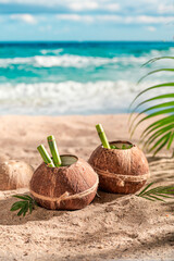 Fresh and tasty pinacolada in coconut on sandy beach.