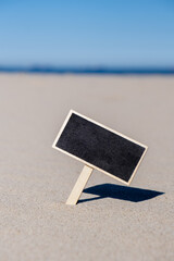 Empty blackboard frame board with copy space for your text or design displays on sandy beach. Summer vacation and holiday business travel concept. Template Mock up for sale promotion advertisement