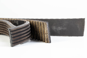 Torn timing belt and generator rivulet belt on a white background. Broken belts in the car, industry, close-up - 787160817