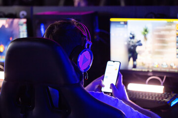 Cybersport tournament Gamer wearing a headset plays video games on a PC in a computer club and...