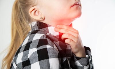 A blonde caucasian girl holds her sore red throat with her hands. Pain and inflammation in the...