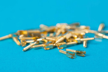 Lots of metal dental pins on a blue background. The concept of installing a tooth and a dental crown on pins in orthodontics, macro