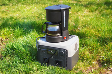 The portable set with power station and electric coffee maker on the green grass. The cooking coffee outdoors or during the blackout. - 787162079