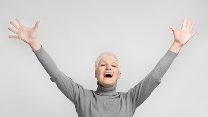 Elderly woman with arms raised and mouth open