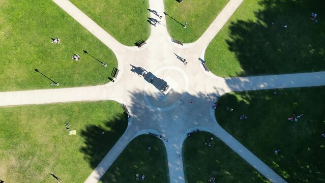 Aerial footage of the visitors at the Queen Square Park on a sunny day with trees shadows in Bristol