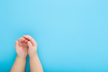 Baby boy opened palms on light blue table background. Pastel color. Closeup. Point of view shot. Empty place for text. Top down view. - 787164601