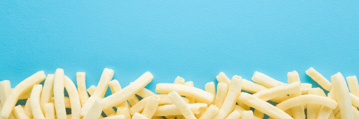 White potato chips sticks on light blue table background. Pastel color. Closeup. Food wide banner. Empty place for text. Top down view. - 787164649