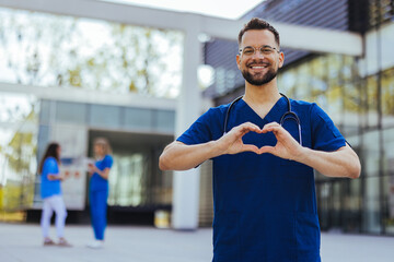 Closeup shot of a medical practitioner making a heart shape with his hands. Cheerful male surgeon...