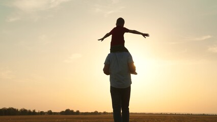 silhouette father carrying child boy his shoulders sunsethappy family, family outdoor activity,...