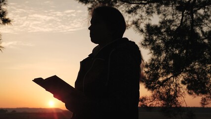 girl woman praying at sunset, hand sunset faith pain, asking heaven for help, bible book, young...