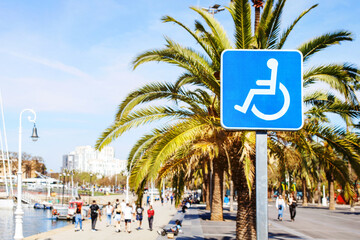 sign for disabled people in a resort town against the backdrop of palm trees