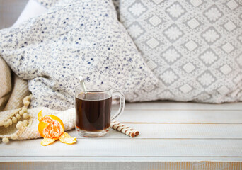 Cozy still life with black coffee and tangerine
