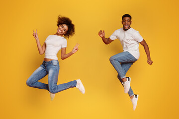 Fototapeta na wymiar Cheerful african-american guy and girl running in air