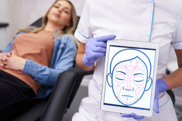 Doctor presenting digital tablet with face lifting sketch - 787188006
