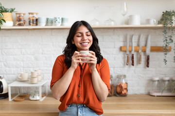 Woman savoring a warm drink at home