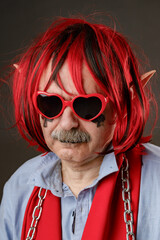 Portrait of an old harmless elf wearing red heart-shaped sunglasses. - 787195209