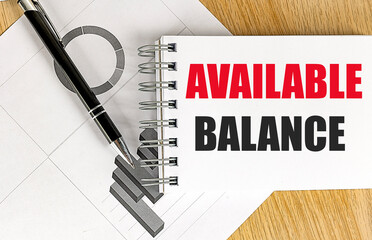 AVAILABLE BALANCE text on notebook with chart on wooden background
