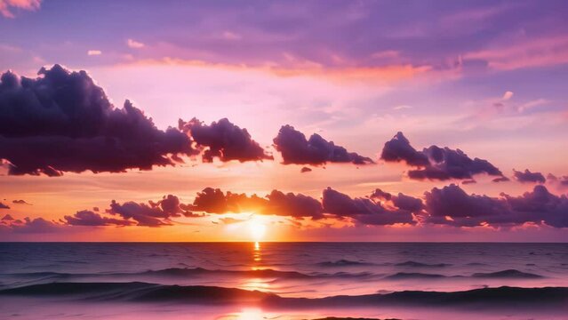 Video animation of  tranquil beach scene at sunset. The sun is close to the horizon, casting a warm glow that lights up the scattered clouds