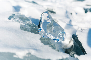 Pieces of ice lying on the ideal smooth ice of baikal with ice hummocks in the horizon