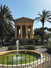 fountain in the park with a old monument with columns in the Malta, Valletta