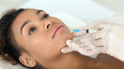Close-up of aesthetic procedure on face for black lady