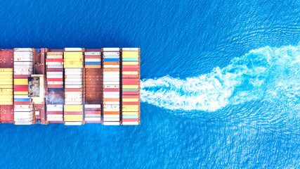 Top view Container ship full capacity approaching the port by a tugboat occupying the port International Container ship loading, unloading at sea port, Freight Transportation, Shipping,  Logistics,