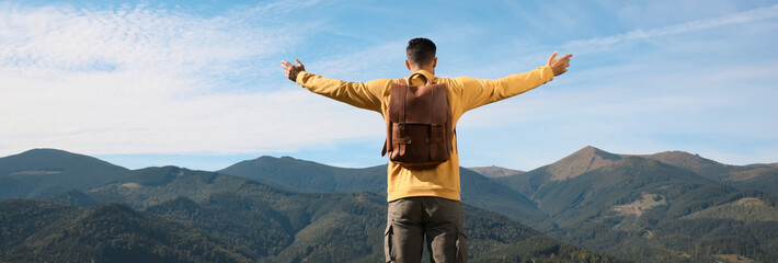 Tourist in mountains on sunny day, back view. Banner design