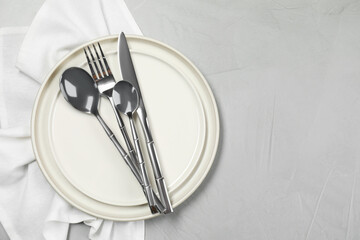 Stylish setting with elegant cutlery on grey table, top view. Space for text