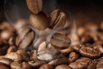 Roasted coffee beans falling on heap against dark background, closeup