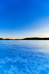 Beautiful winter sunset in small forest lake