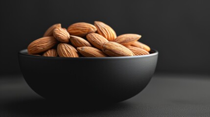 Almonds in a textured bowl on dark background, a study in healthy snacking
