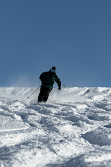 Naklejka na ściany i meble Skier skiing in the Swiss alps off-piste in white snow