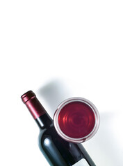 Bottle and glass of red wine on a white background. Vertical image.