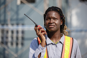 African American women general employee operational level wear yellow hard hat holding talkie...
