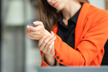 Woman have wrist pain after work hard in office, office syndrome concept.