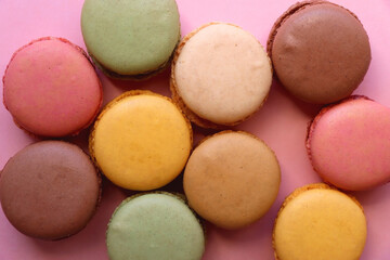 Colorful macarons on pink background. Top view.